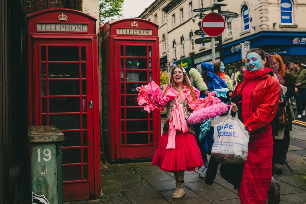 Danseuse devant une cabine téléphonique