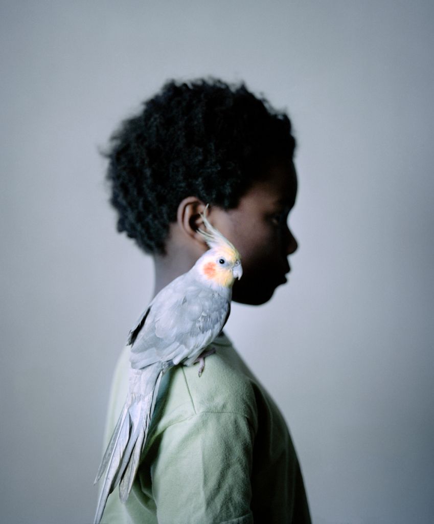 Portrait de Tina Merandon montrant une jeune fille avec un oiseau exotique sur l'épaule