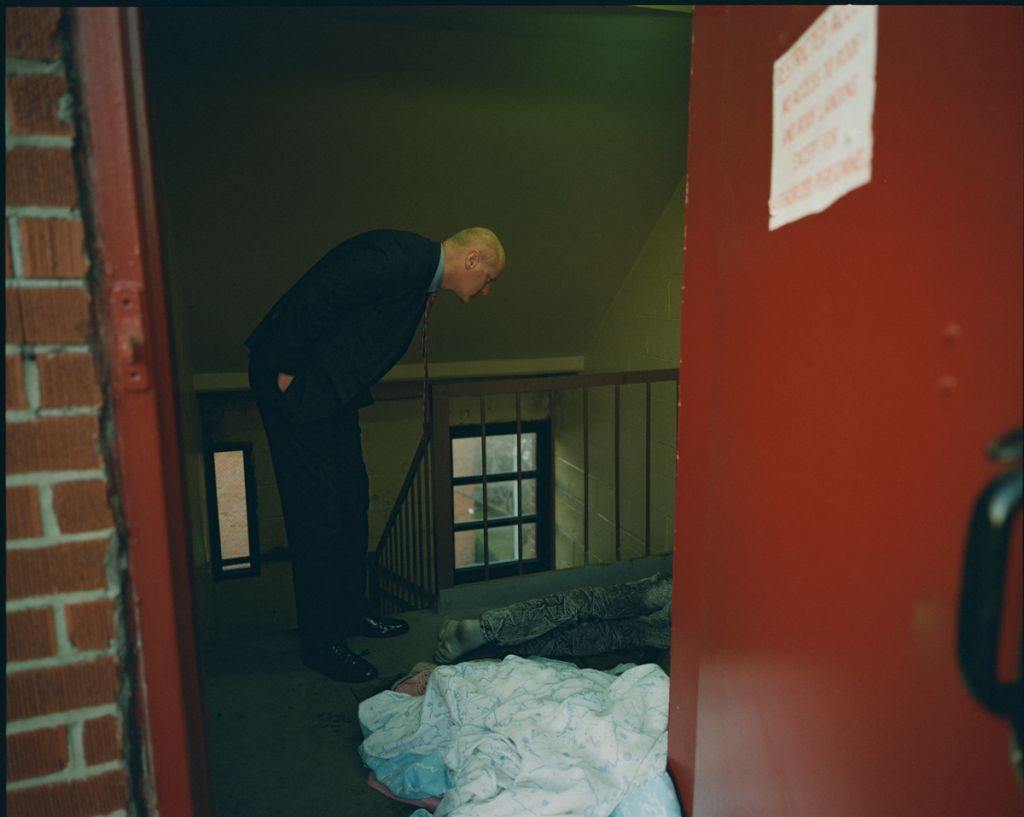 L'inspecteur Al Brust examine une victime abattue dans une cage d'escalier menant au toit de l'immeuble.