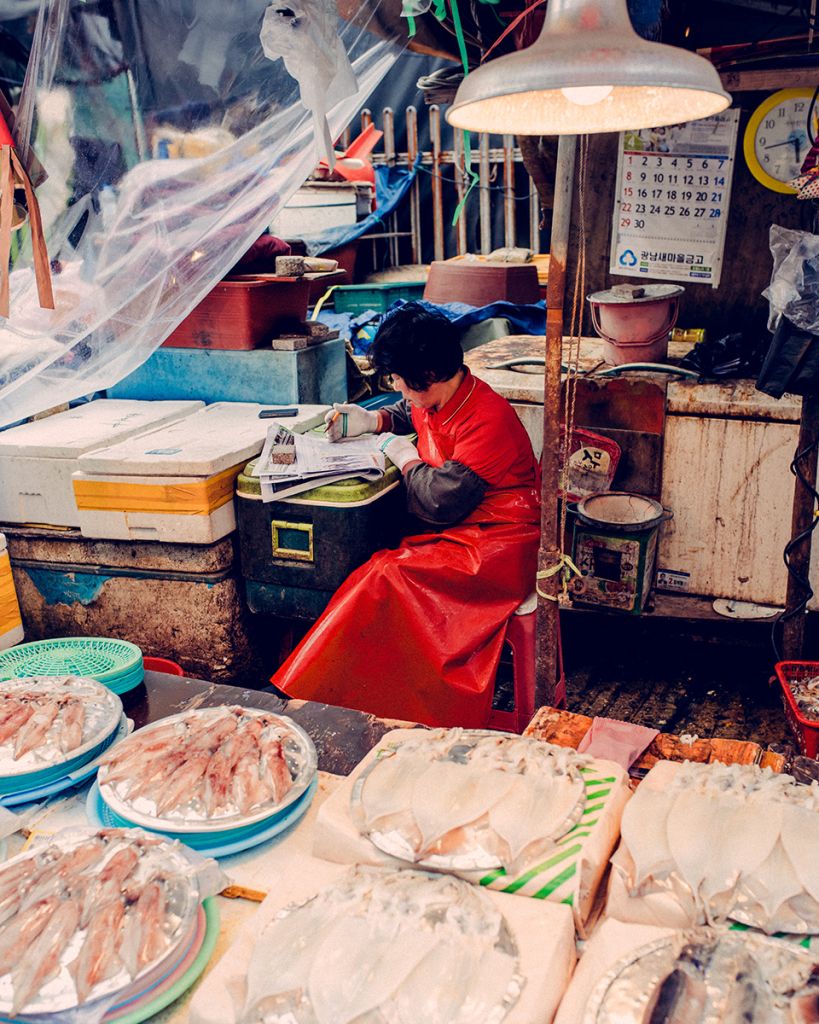 Une femme qui tient un stand de poisson au marché en Corée du Sud