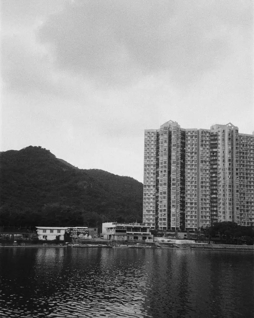 Paysage urbain avec en fond un montagne et en premier-plan un lac.