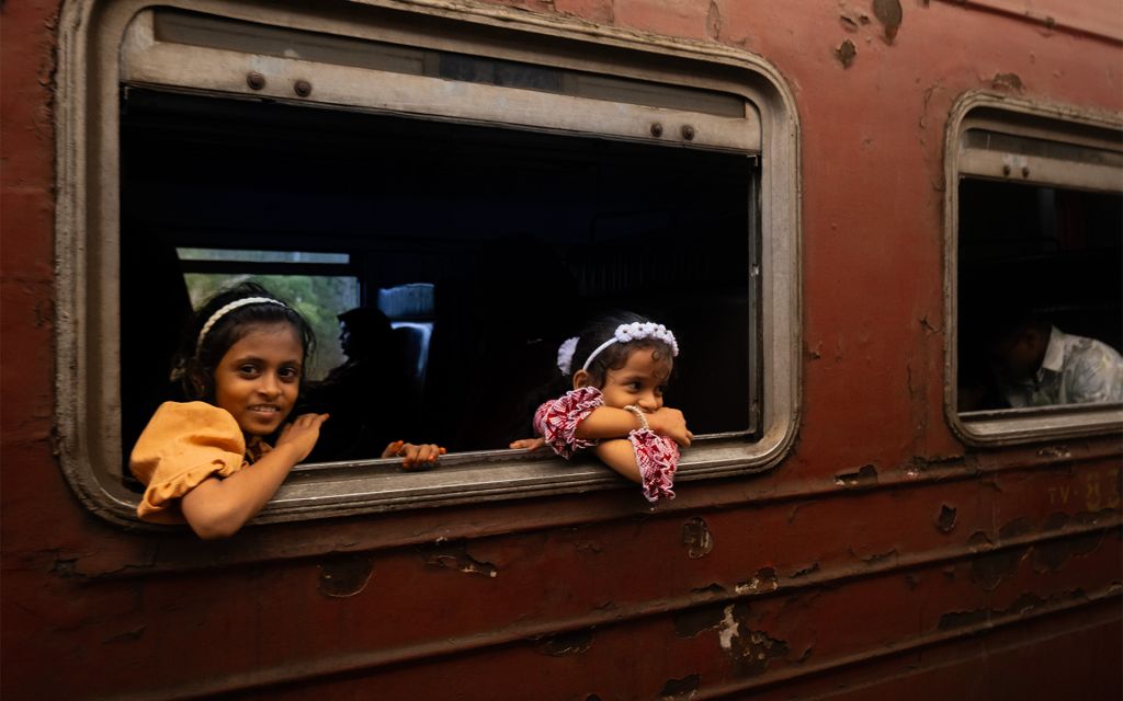 Deux petites filles sont à la fenêtre d'un train au Sri Lanka