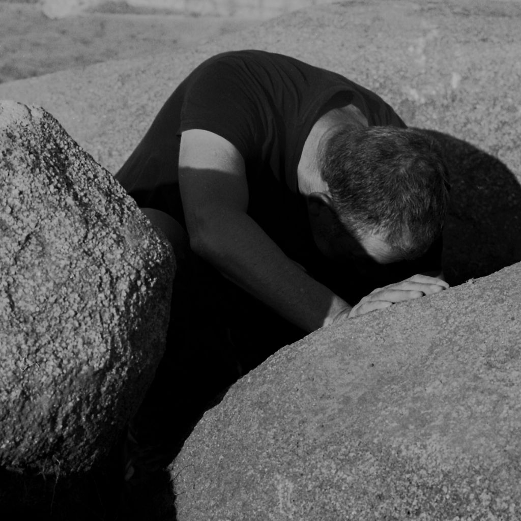 Homme cherchant quelque chose entre des rochers