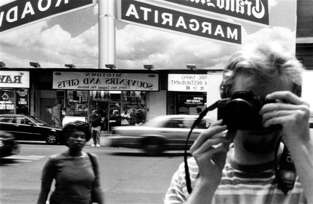 Un photographe se prend en photo dans le reflet d'un miroir dans la rue