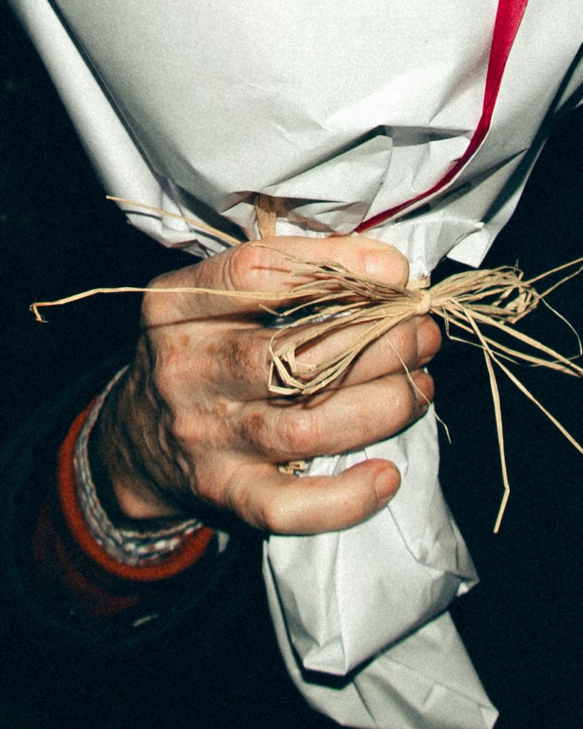 Une main qui tient un bouquet emballé dans la nuit