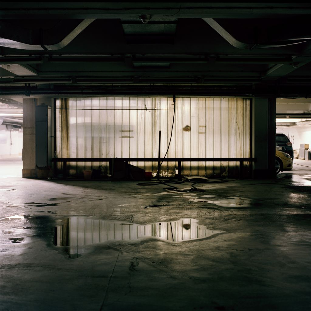 sous-sol qui ressemble à un parking, une flaque d'eau au sol