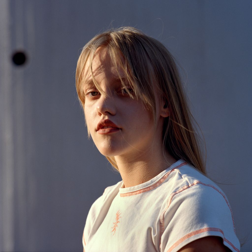 Portrait d'une jeune femme blonde devant la Genex Tower à Belgrade