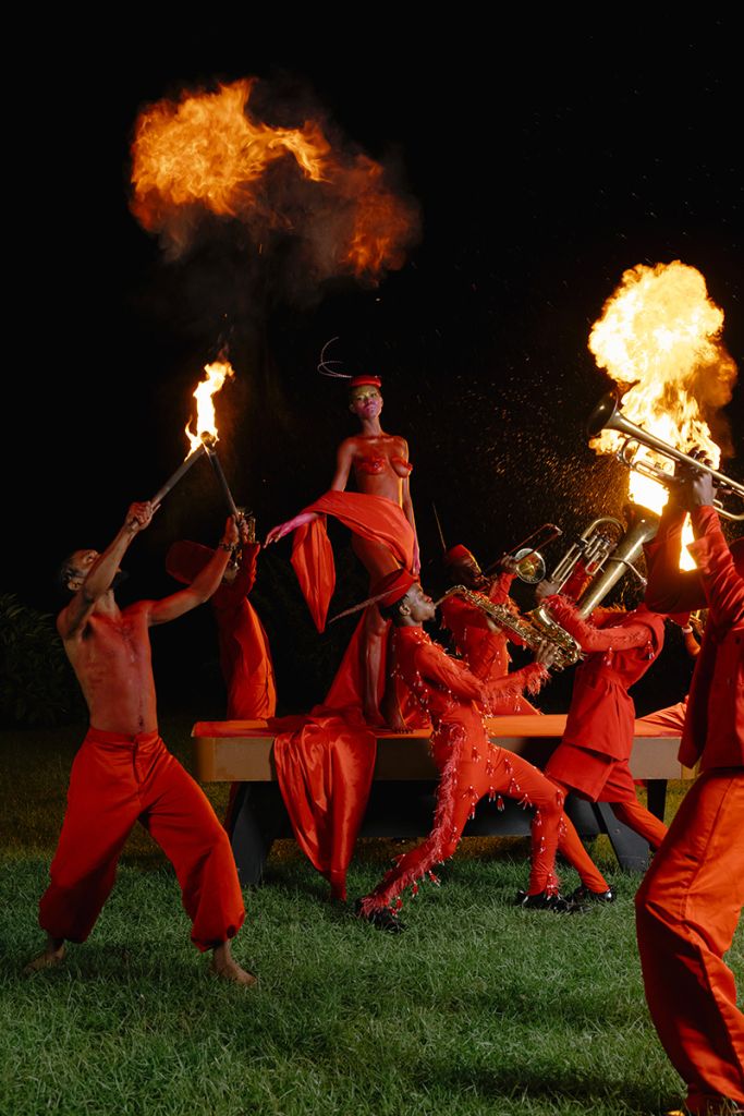Des personnes en orange dansent avec du feu dans la nuit