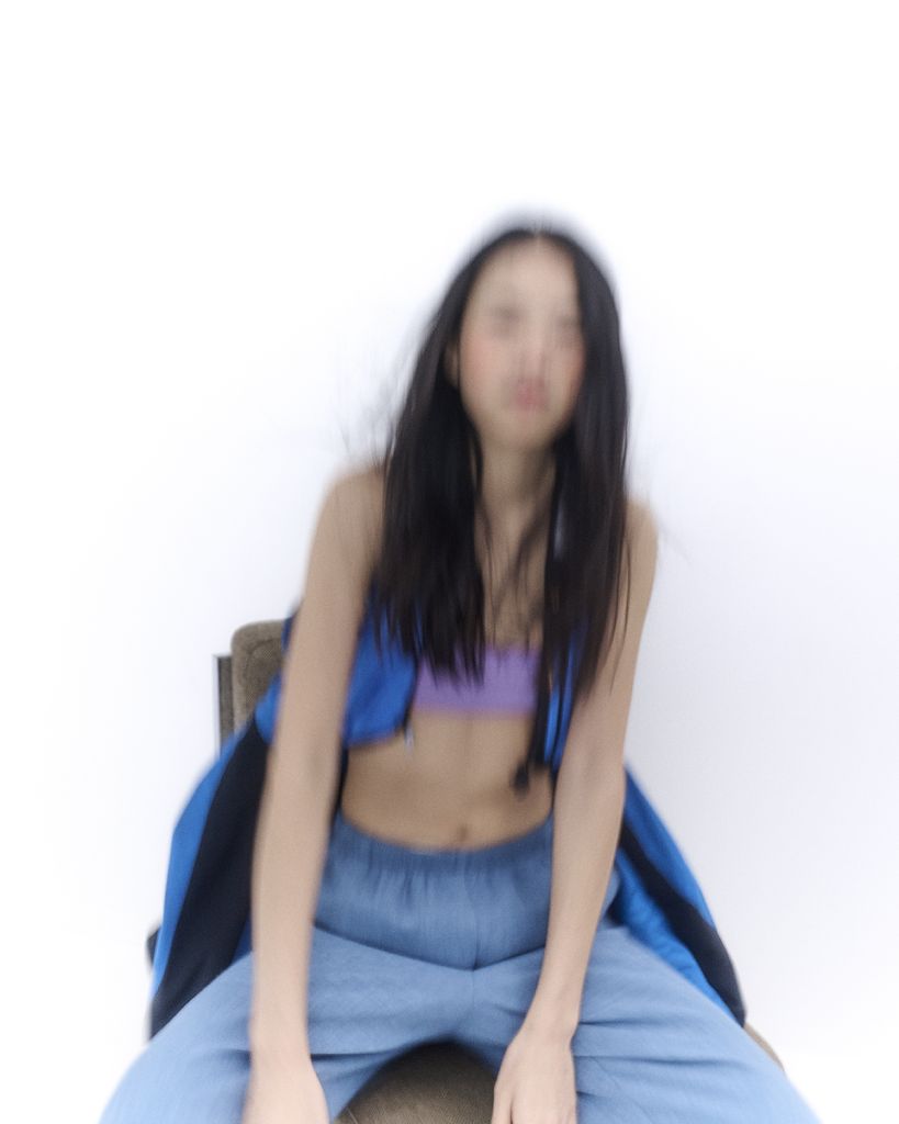 Une femme assise dont le visage est flou