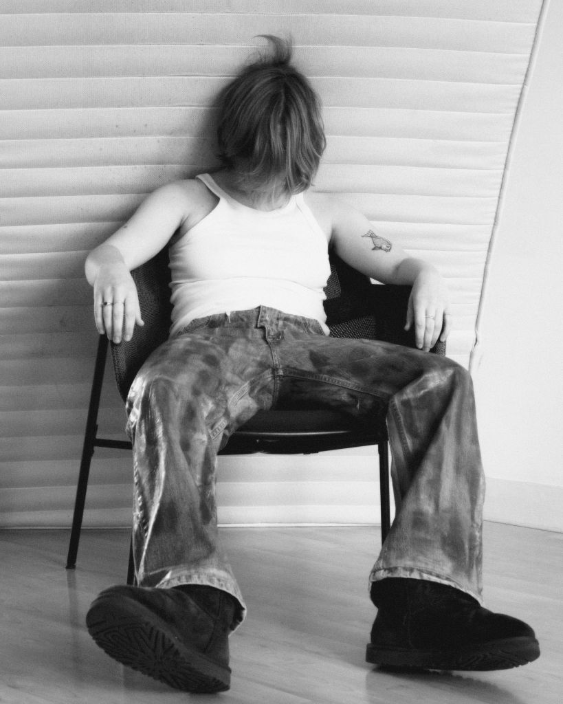 Une personne est avachie sur une chaise, la tête baissée, le corps lâchant prise 