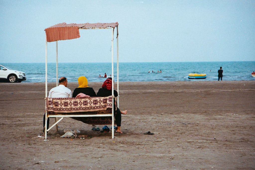 Des personnes assises de dos sur une balancelle face à la mer