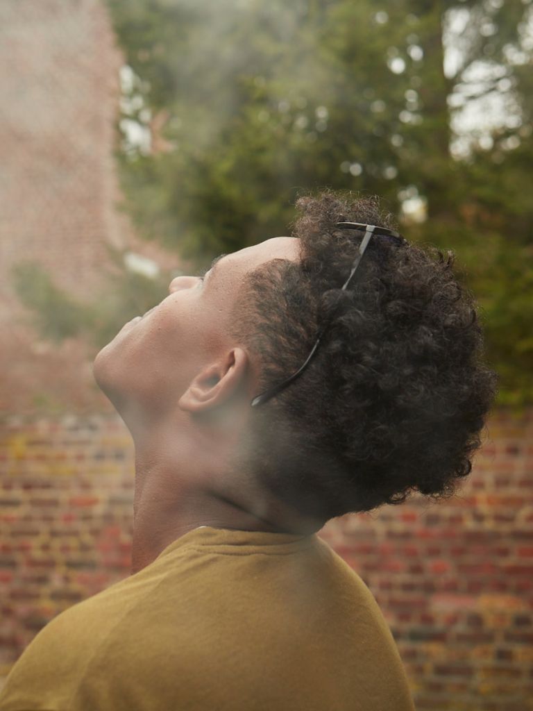 Portrait d’un homme en extérieur, vu de trois quarts arrière, regard vers le ciel