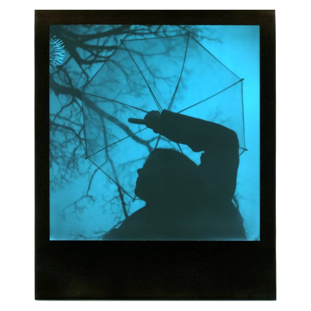 Polaroid d'une silhouette tenant un parapluie