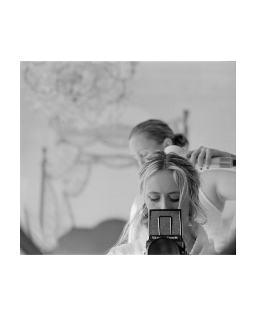 Une jeune femme se prend en photo avec sa mère semble lui sécher les cheveux. 