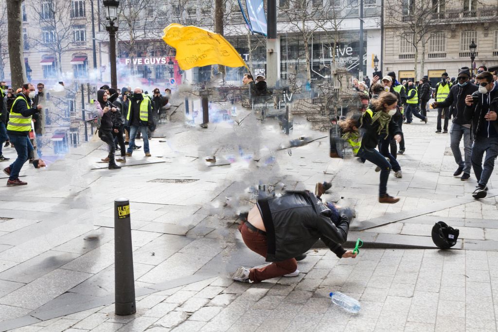 Manifestant de protégeant des gaz lacrymogènes lors de manifestations à Paris.