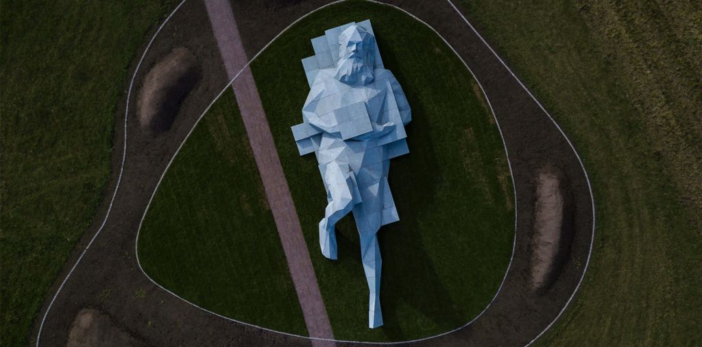 Une sorte de statue grecque en 3D est allongée dans un parc.