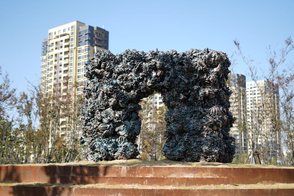 Une sculpture en laiton prenant la forme d'un portail installé au milieu d'un parc en Chine.