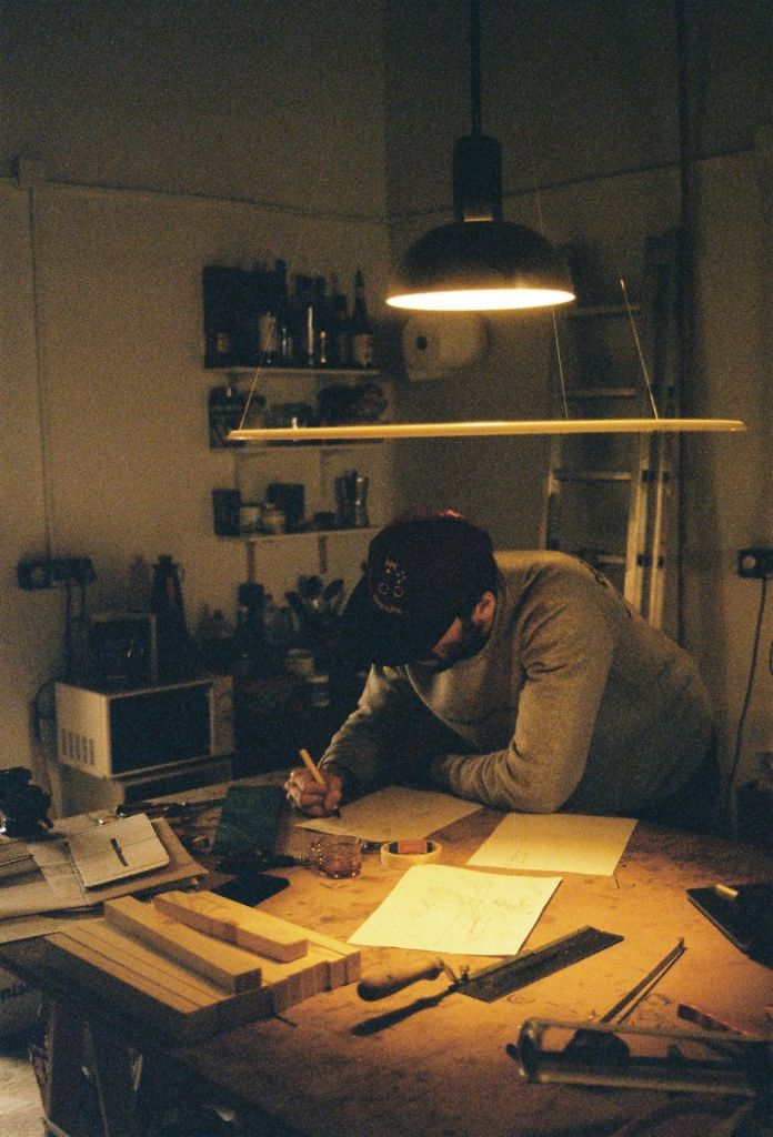 Un homme travaillant dans son studio, entouré d'outils.